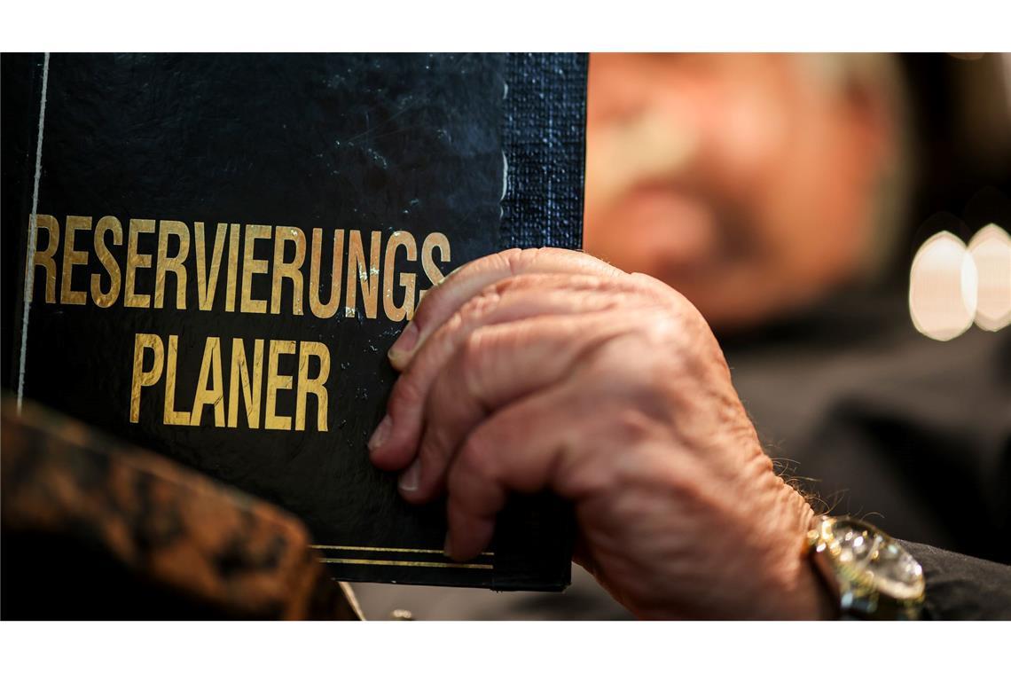 Wie die Gastronomie Gäste-Ghosting kontert Altmodisch? Ein Gastronom schaut in sein Reservierungsbuch.