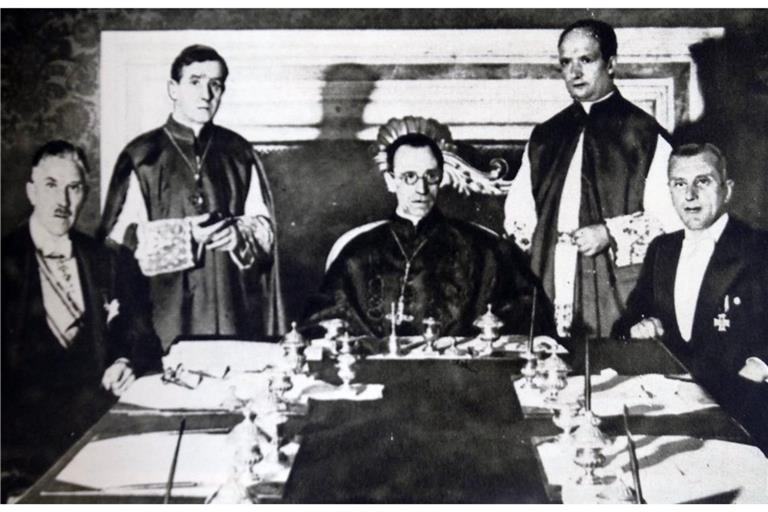 Am 20. Juli 1933 unterzeichnen Kardinalstaatssekretär Eugenio Pacelli und Franz von Papen das Reichskonkordat zwischen dem Deutschen Reich und dem Heiligen Stuhl (auf dem Foto sind zu sehen von links nach rechts: Prälat Ludwig Kaas, Vizekanzler Franz von Papen, Unterstaatssekretär Giuseppe Pizzardo, Kardinalstaatssekretär Eugenio Pacelli und Ministerialdirektor Rudolf Buttmann während des Unterzeichnungsaktes; zwischen Pacelli und Buttmann stehend: Substitut Alfredo Ottaviani.