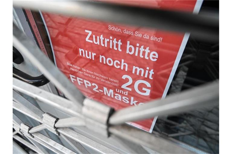 Am Eingang eines Ladens in der Ravensburger Innenstadt wird auf die Maskenpflicht und die 2G-Regel hingewiesen. Foto: Felix Kästle/dpa
