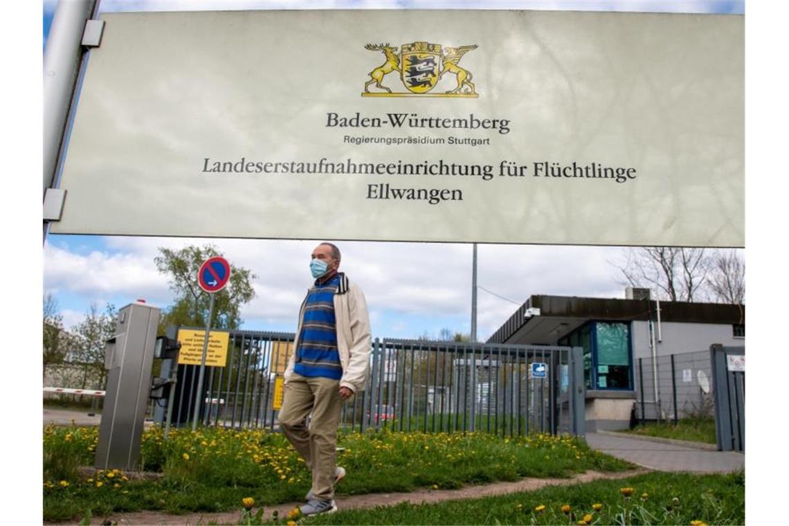 Ellwangen: Rätsel um hohe Zahl coronainfizierter Flüchtlinge Am Eingang zur Landeserstaufnahmeeinrichtung für Flüchtlinge (LEA) geht ein Mann mit Maske vorbei. Foto: Stefan Puchner/dpa
