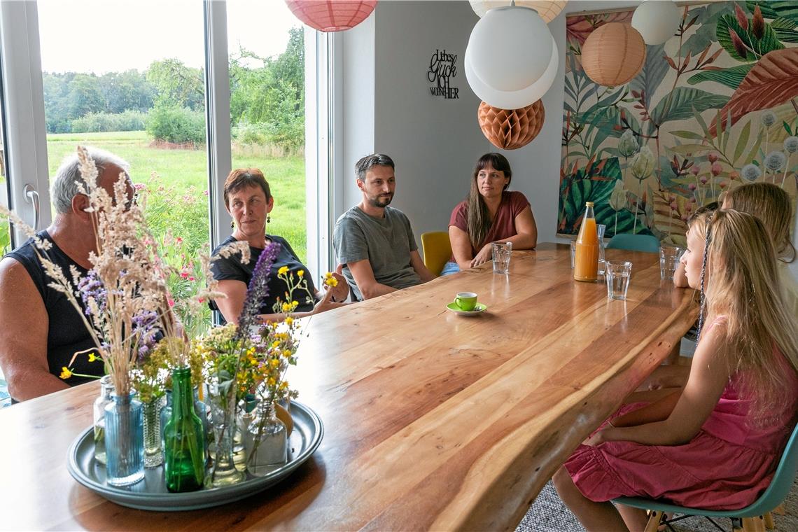 Am großen Esstisch wird im Gespräch der eigene Tag reflektiert (von links): Klient Herr E., Karin Mayländer-Friedrich, Tobias Schad, Hanne-Rose Schad und die drei Kinder Lene, Lotte und Lorenz. Foto: Alexander Becher