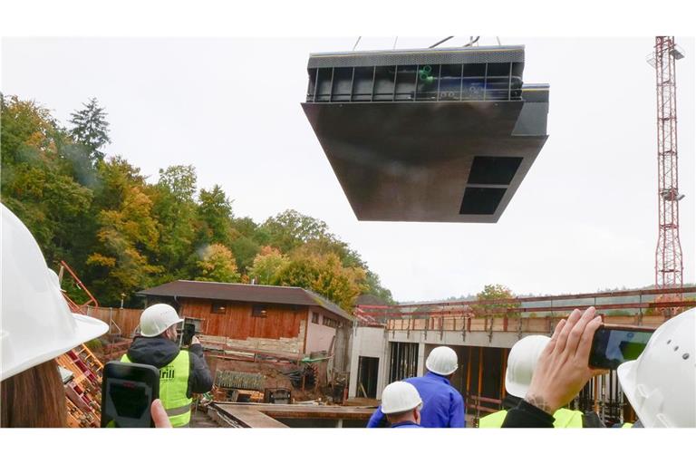 Am Haken eines Schwerlastkrans segelt das Außenbecken auf die Baustelle.