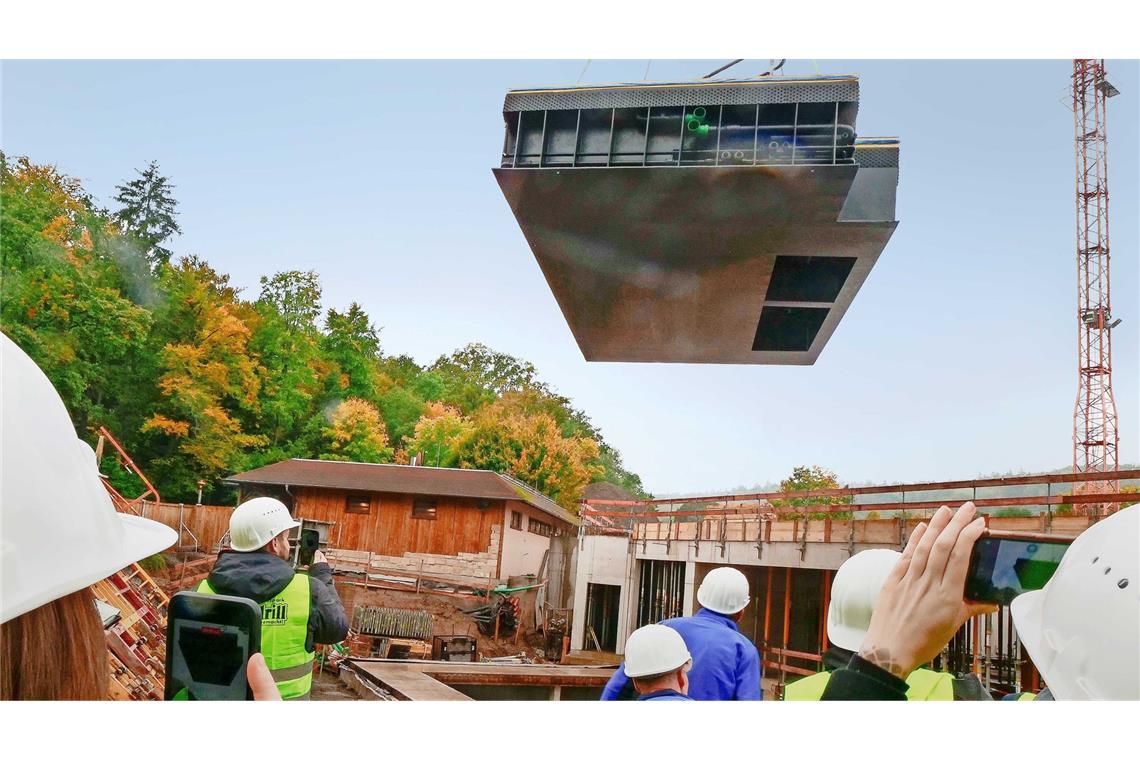 Am Haken eines Schwerlastkrans segelt das Außenbecken auf die Baustelle.