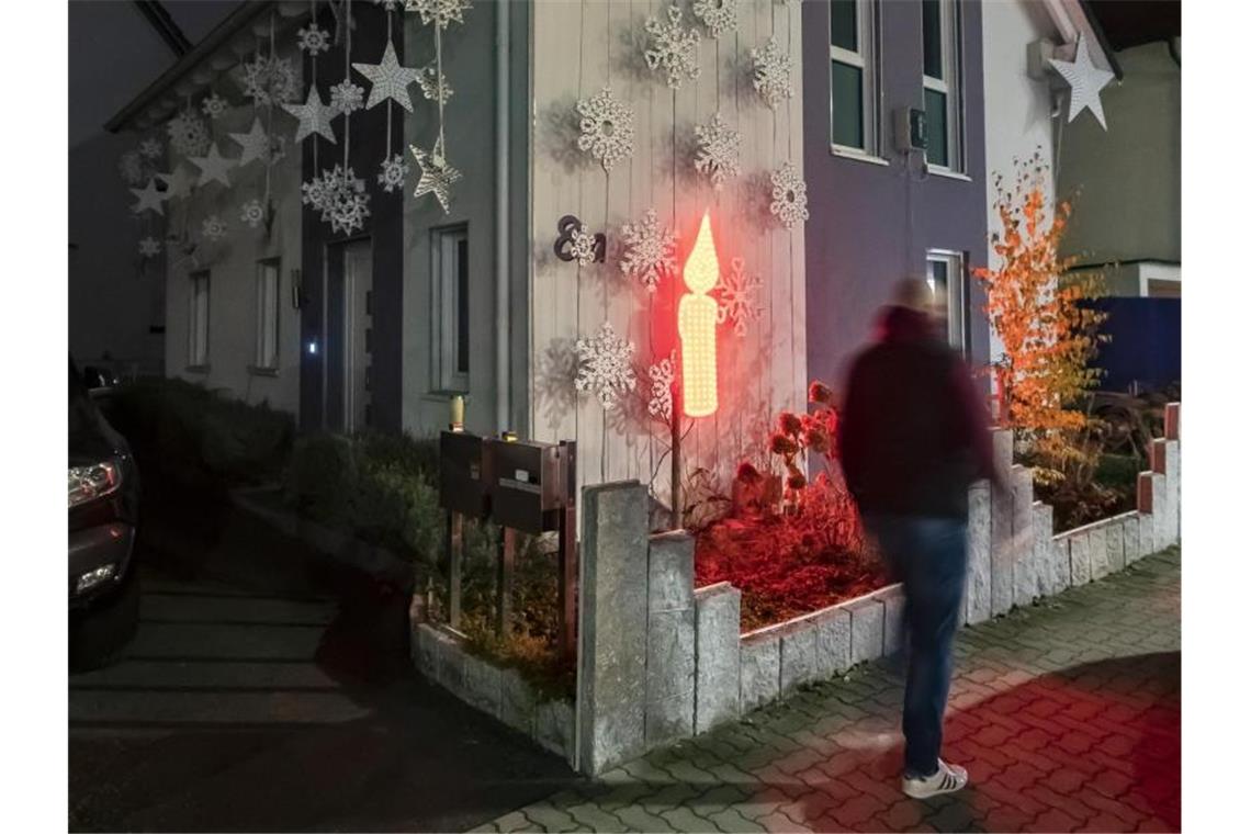 Am Haus von Thorsten Grüger ist von ihm eine rot leuchtende LED Kerze angebracht. Foto: Uli Deck/dpa
