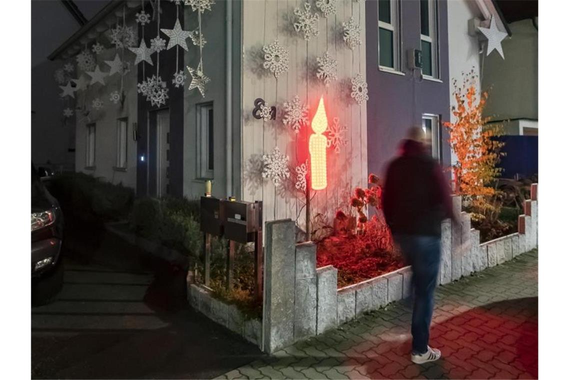 Weihnachtshäuser lassen wegen Corona die Lichter aus Am Haus von Thorsten Grüger ist von ihm eine rot leuchtende LED Kerze angebracht. Foto: Uli Deck/dpa