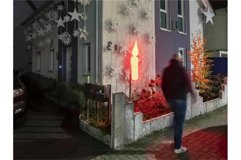 Am Haus von Thorsten Grüger ist von ihm eine rot leuchtende LED Kerze angebracht. Foto: Uli Deck/dpa