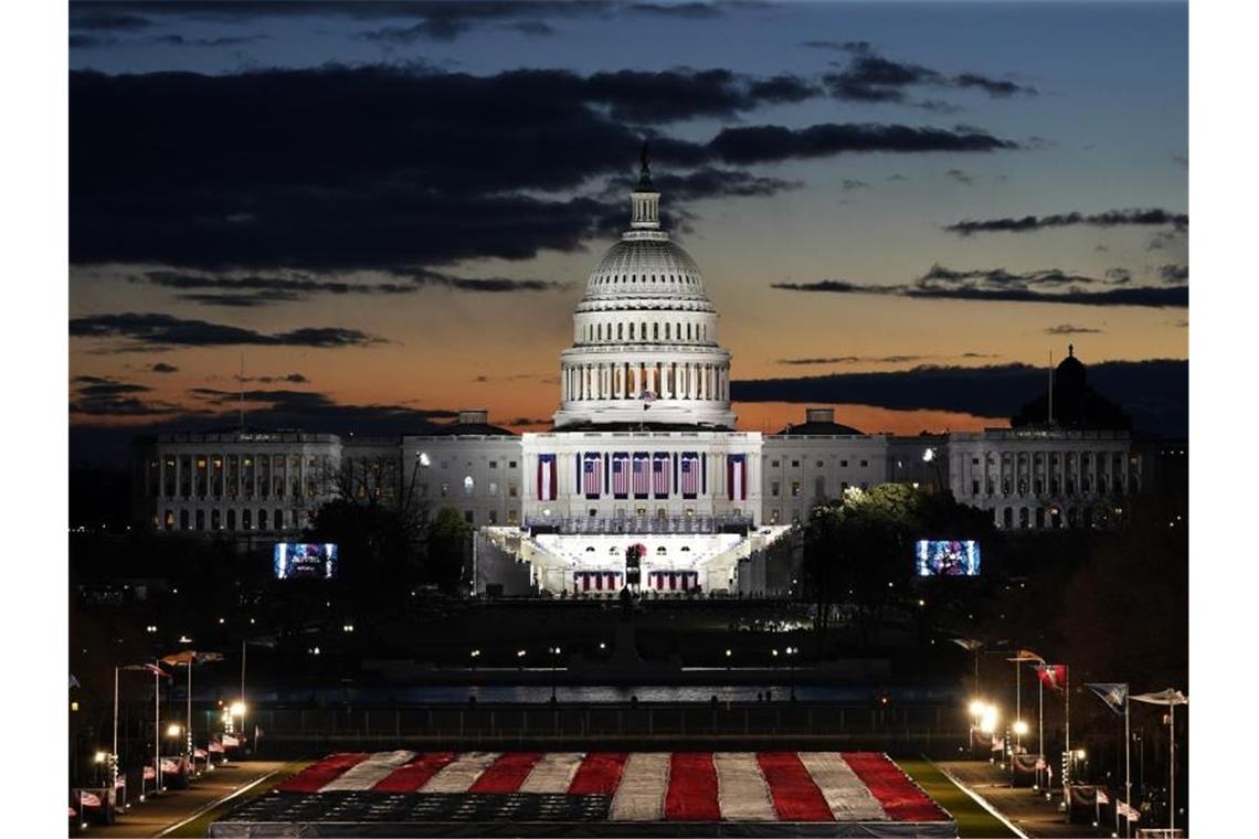 Am Morgen der Amtseinführung von Joe Biden dämmert es am Himmel über dem beleuchteten Kapitol und der Bühne für die Vereidigung. Foto: Julio Cortez/AP/dpa