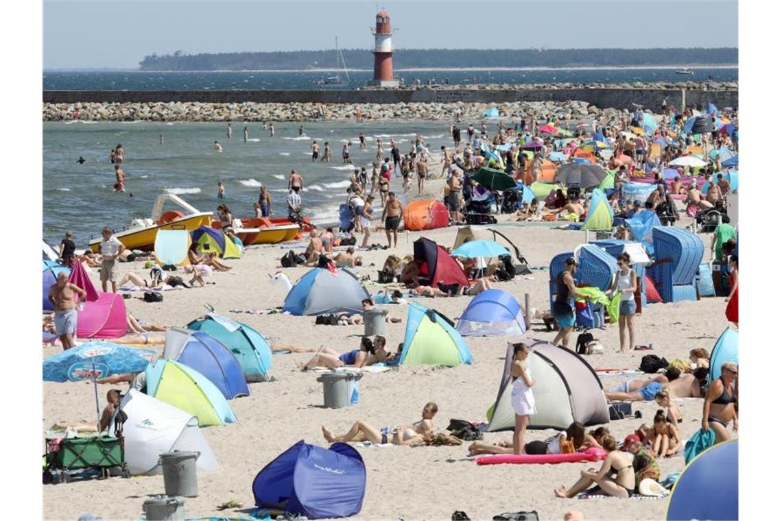 Am Ostseestrand von Warnemünde herrscht Hochbetrieb. Strandmuscheln und Sonnenschirme bestimmen das Bild. Foto: Bernd Wüstneck