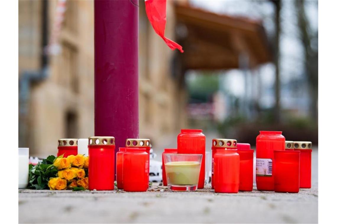 Am Tag nach den tödlichen Schüsse in Rot am See liegen Blumen und Kerzen vor dem Tatort. Foto: Tom Weller/dpa