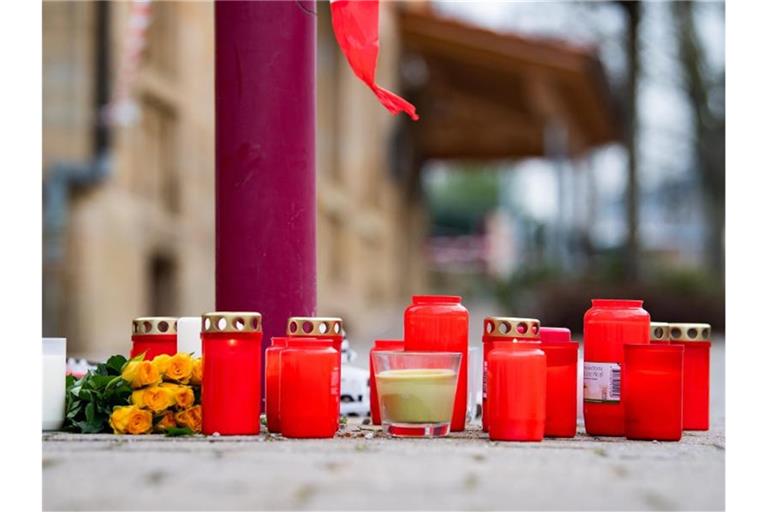 Am Tag nach den tödlichen Schüsse in Rot am See liegen Blumen und Kerzen vor dem Tatort. Foto: Tom Weller/dpa