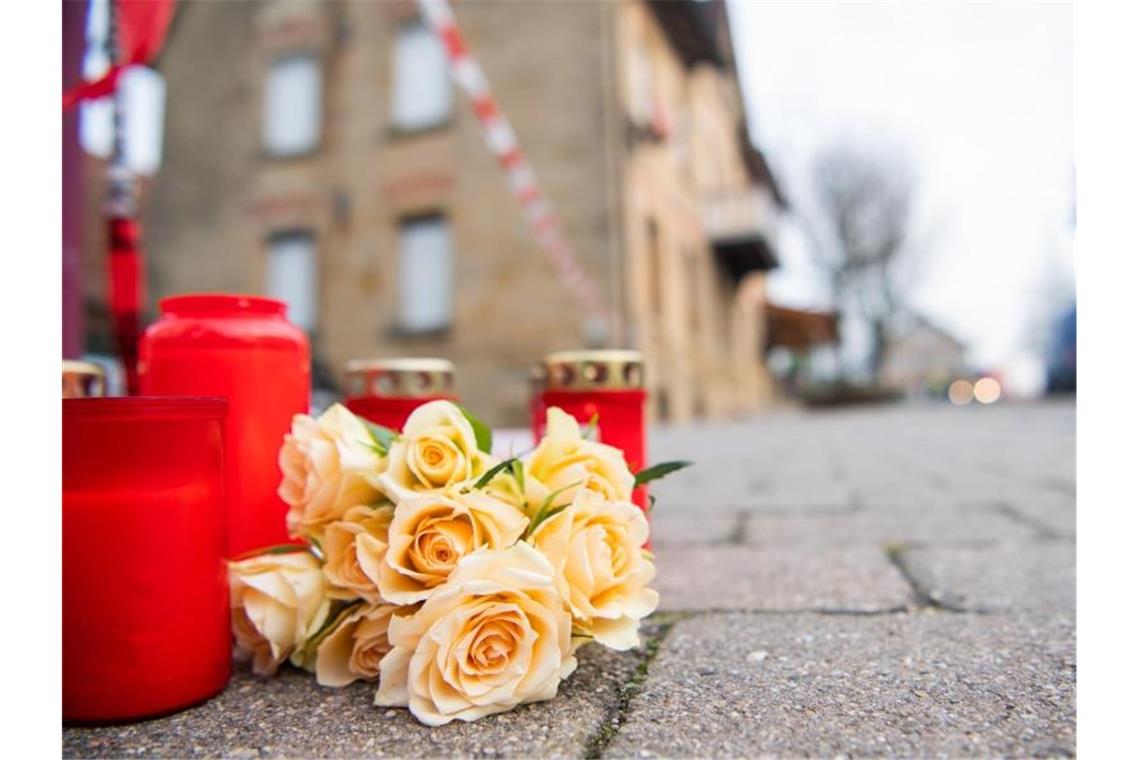 Am Tag nach den tödlichen Schüssen in Rot am See liegen Blumen und Kerzen vor dem Tatort. Foto: Tom Weller/dpa/Archivbild
