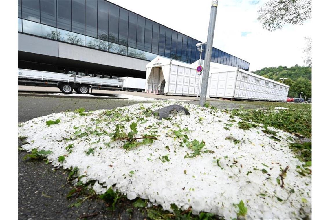 Am Tag nach einem Unwetter liegen noch Hagelkörner vor dem Impfzentrum in Tübingen. Foto: Bernd Weißbrod/dpa