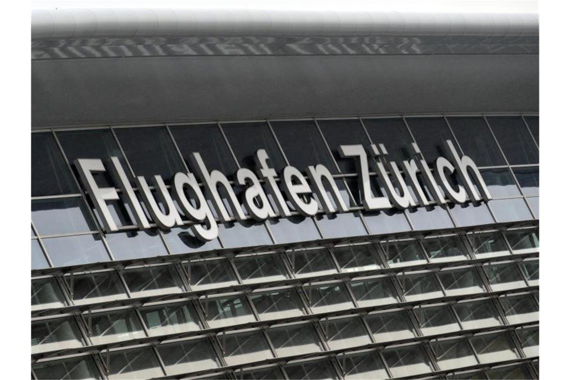 Flugzeug kurz nach Start in Zürich von Blitz getroffen Am Terminal des Flughafens von Zürich steht „Flughafen Zürich“. Foto: Andreas Gebert/Archivbild
