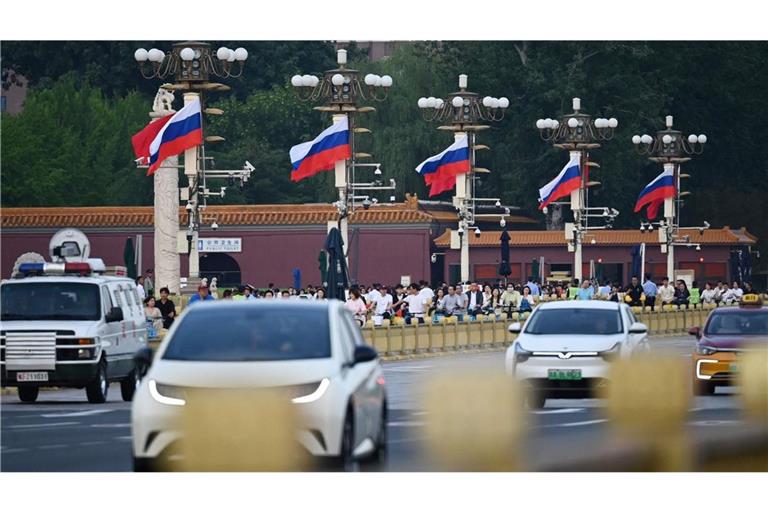 Am Tiananmen Platz rollt der Verkehr an russischen Fahnen vorbei.