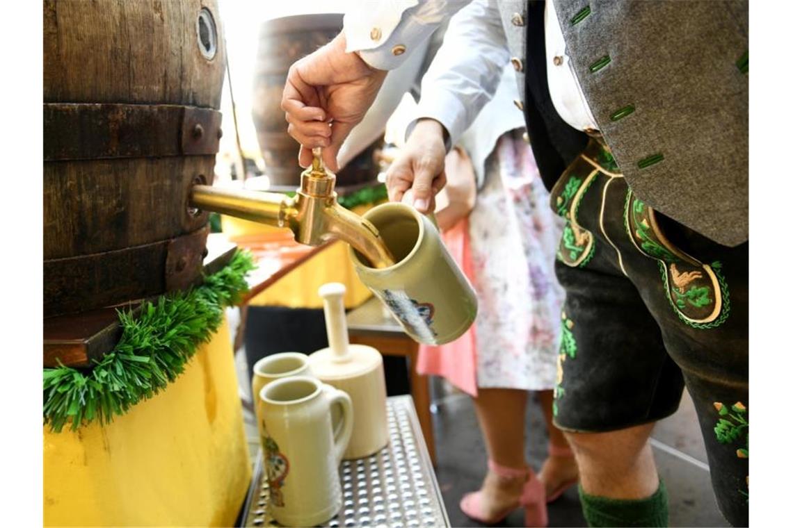 „Ozapft is“: München feiert auch ohne Oktoberfest Am Viktualienmarkt wird eifrig gezapft. Foto: Angelika Warmuth/dpa