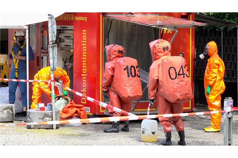 Ammoniak ausgetreten - Feuerwehrleute in Schutzanzügen werden bei einem Einsatz auf dem Campus der Universität Hamburg dekontaminiert.
