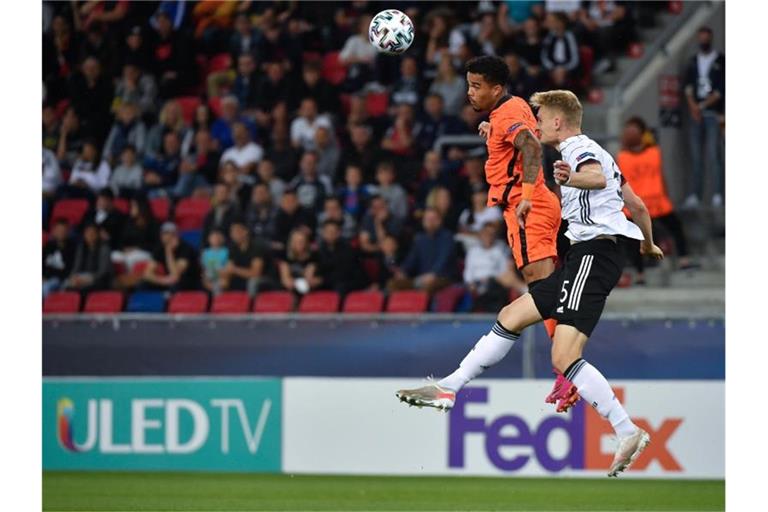 Amos Pieper (r) kämpft mit dem Niederländer Justin Kluivert um den Ball. Foto: Marton Monus/dpa