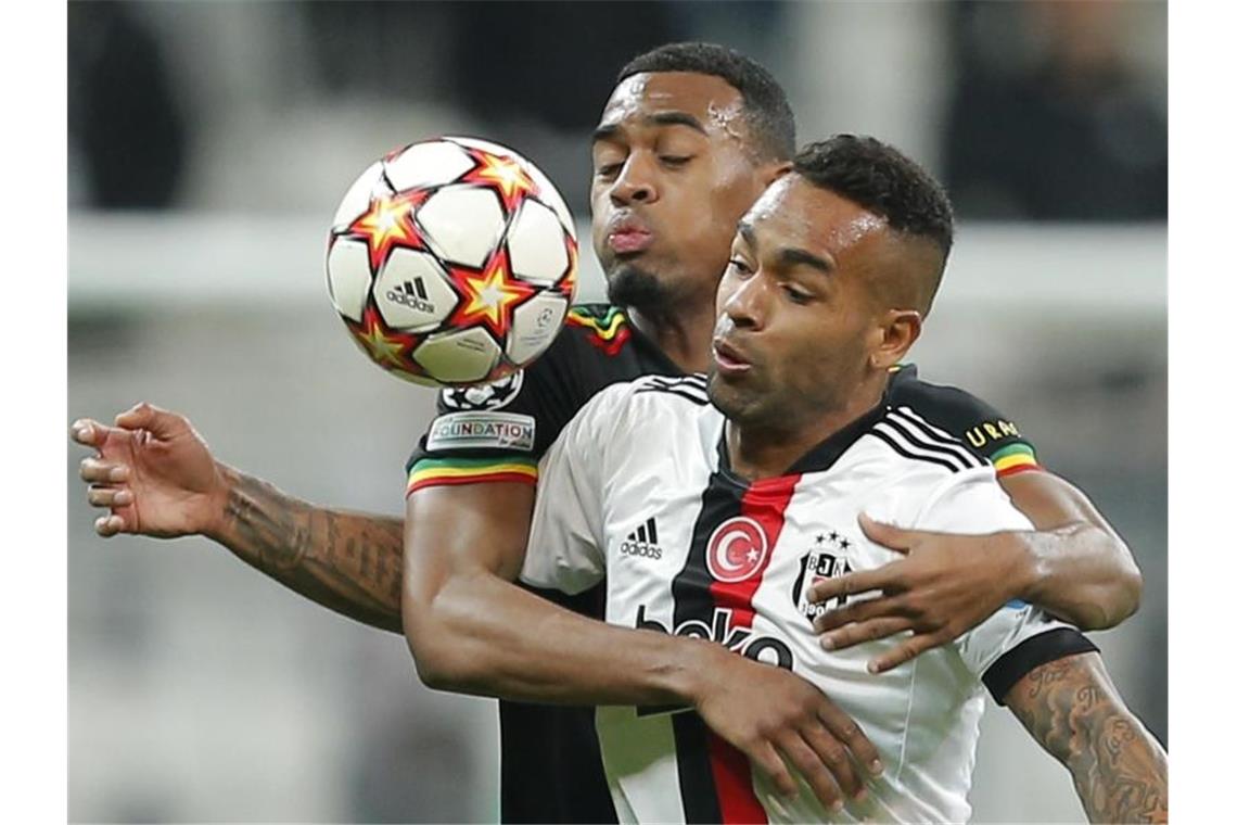 Amsterdams Ryan Gravenberch (hinten) hält Besiktas Alex Teixeira mit den Armen zurück. Foto: -/AP/dpa