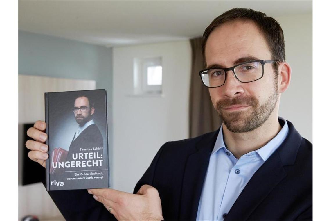 Amtsrichter Thorsten Schleif zeigt sein Buch mit dem Titel „Urteil ungerecht“. Foto: Thomas Frey/dpa