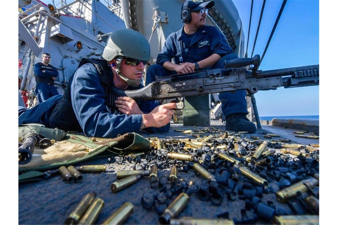 An Bord des Zerstörers USS Mitscher im Golf von Oman hält ein US-Soldat ein Maschinengewehr im Anschlag. Foto: Jacob Milham/US Navy