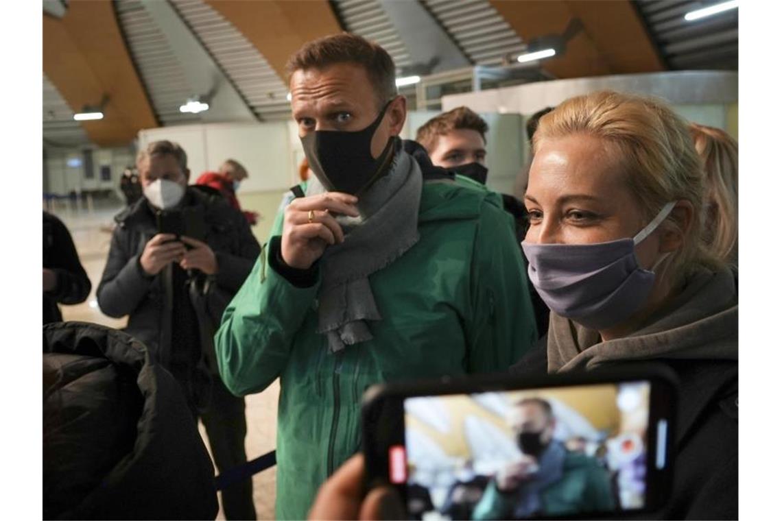 An der Passkontrolle ist Kremlkritiker Alexej Nawalny (M) - hier mit seiner Frau Julia - abgeführt worden. Foto: Mstyslav Chernov/AP/dpa