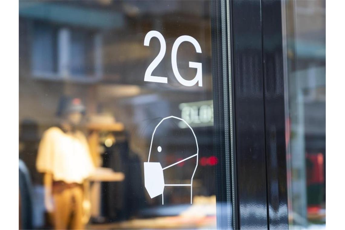 Innenstädte setzen auf 2G-Bändchen: „Positive Rückmeldungen“ An der Tür an einem Ladengeschäft sind Hinweise zu den Coronaregeln ausgeschildert. Foto: Christophe Gateau/dpa/Archivbild