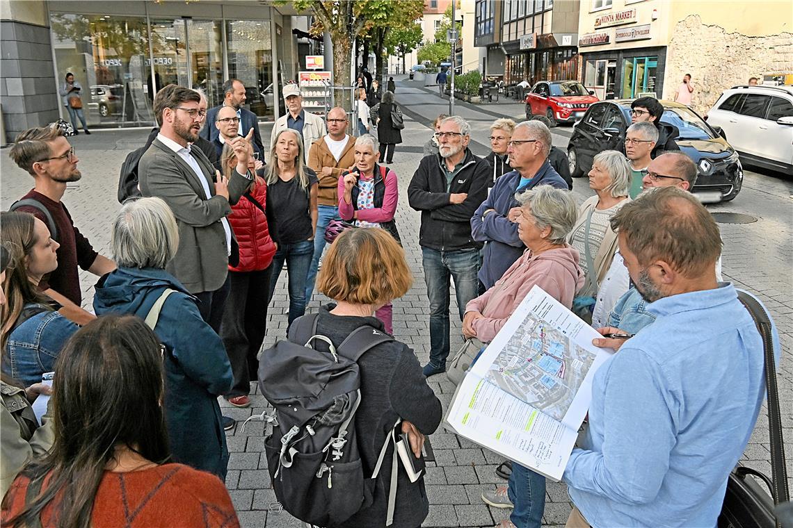 An dieser Stelle in der Backnanger Grabenstraße sollen zukünftig kaum mehr Autos fahren. Tobias Großmann (Mitte links, graues Sakko, weißes Hemd) und Volker Knödler (vorne rechts) vom Stadtplanungsamt erläutern die Pläne der Verwaltung. Foto: Tobias Sellmaier