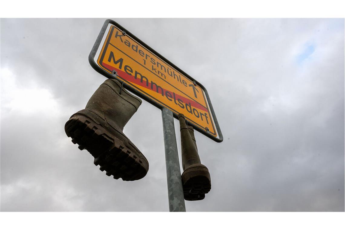 An einem Ortsschild im unterfränkischen Memmelsdorf (Landkreis Haßberge) hängen am Neujahrstag Gummistiefel.