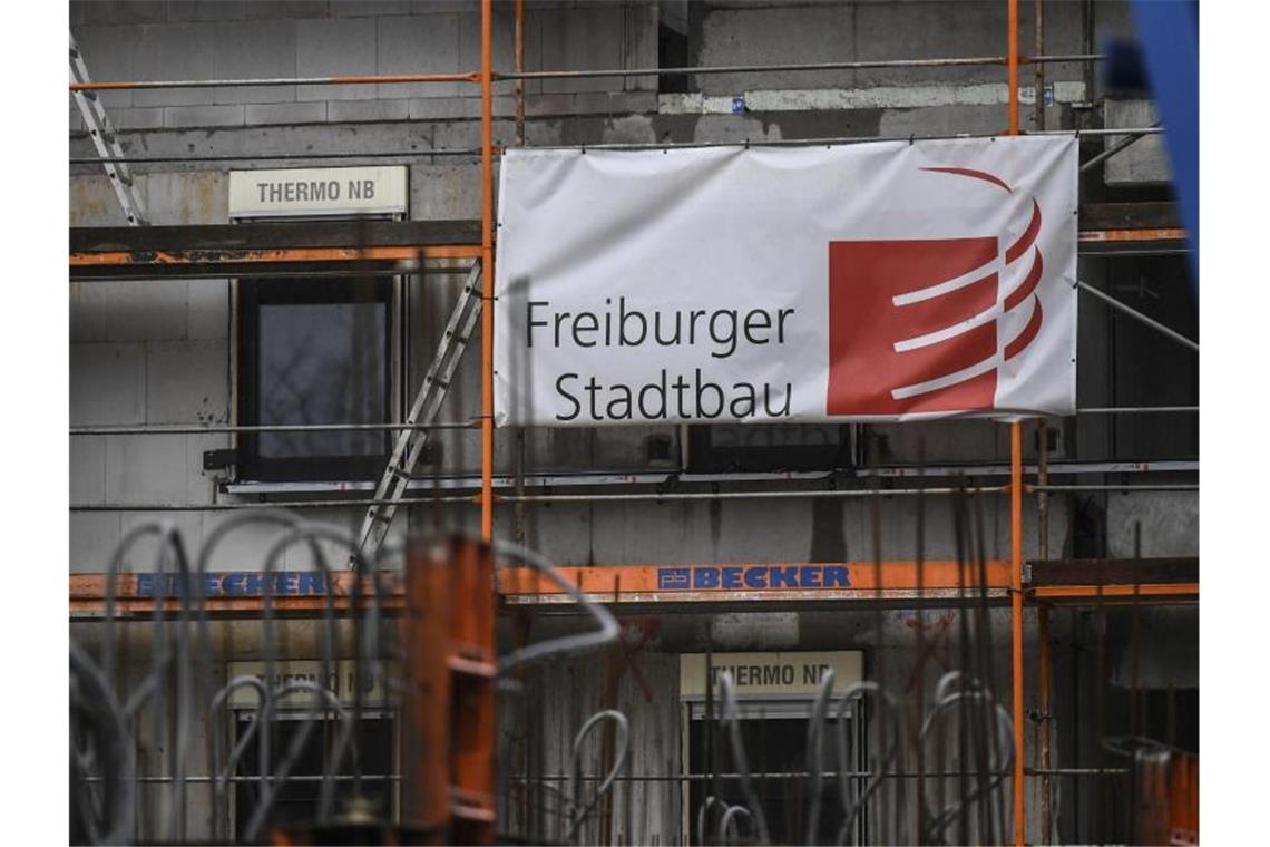 An einem Rohbau hängt ein Banner mit der Aufschrift "Freiburger Stadtbau". Foto: Patrick Seeger/dpa