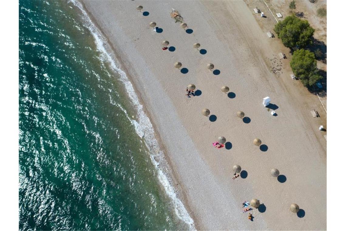 An einem Strand südlich von Athen stehen Sonnenschirme für Strandbesucher bereit. Foto: Lefteris Partsalis/XinHua/dpa