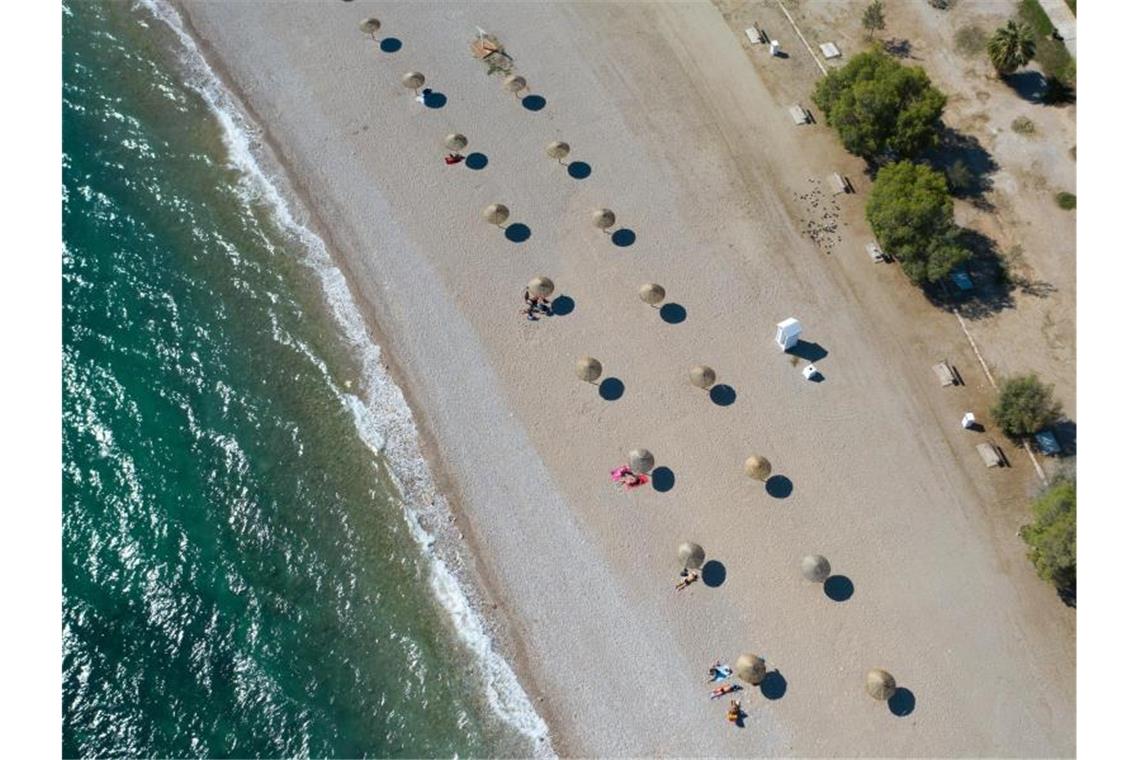 An einem Strand südlich von Athen stehen Sonnenschirme für Strandbesucher bereit. Wegen sinkender Corona-Infektionszahlen streicht die Bundesregierung am Sonntag Griechenland, fast ganz Frankreich, die Schweiz und Belgien von der Liste der Risikogebiete. Foto: Lefteris Partsalis/XinHua/dpa
