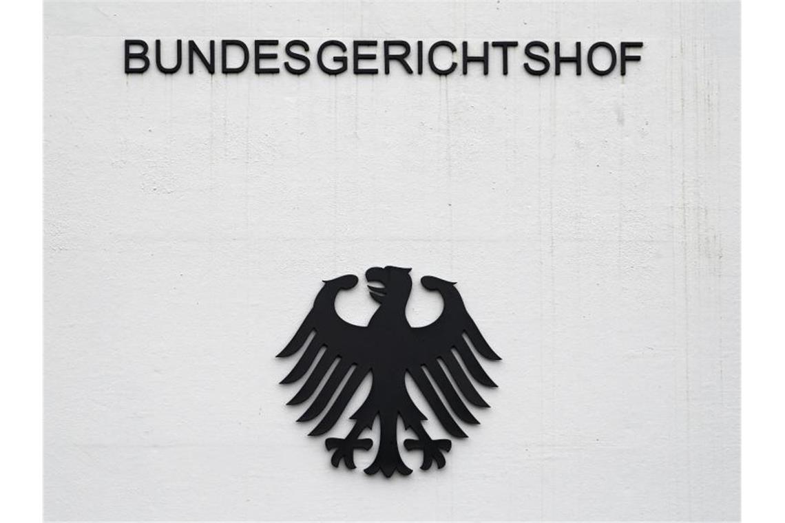 Bundesgerichtshof hebt Urteil nach Messerattacke auf An einer grauen Wand sind der Schriftzug „Bundesgerichtshof“ und Bundesadler in schwarz zu sehen. Foto: Uli Deck/dpa/Archivbild