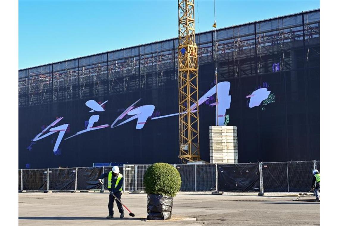 Tesla ist in Deutschland gestartet - Scholz sieht Signal An einer riesigen Plane an einem Baugerüst steht „Giga“ am neuen Werk der Tesla-Fabrik Berlin Brandenburg. Foto: Patrick Pleul/dpa-Zentralbild/dpa