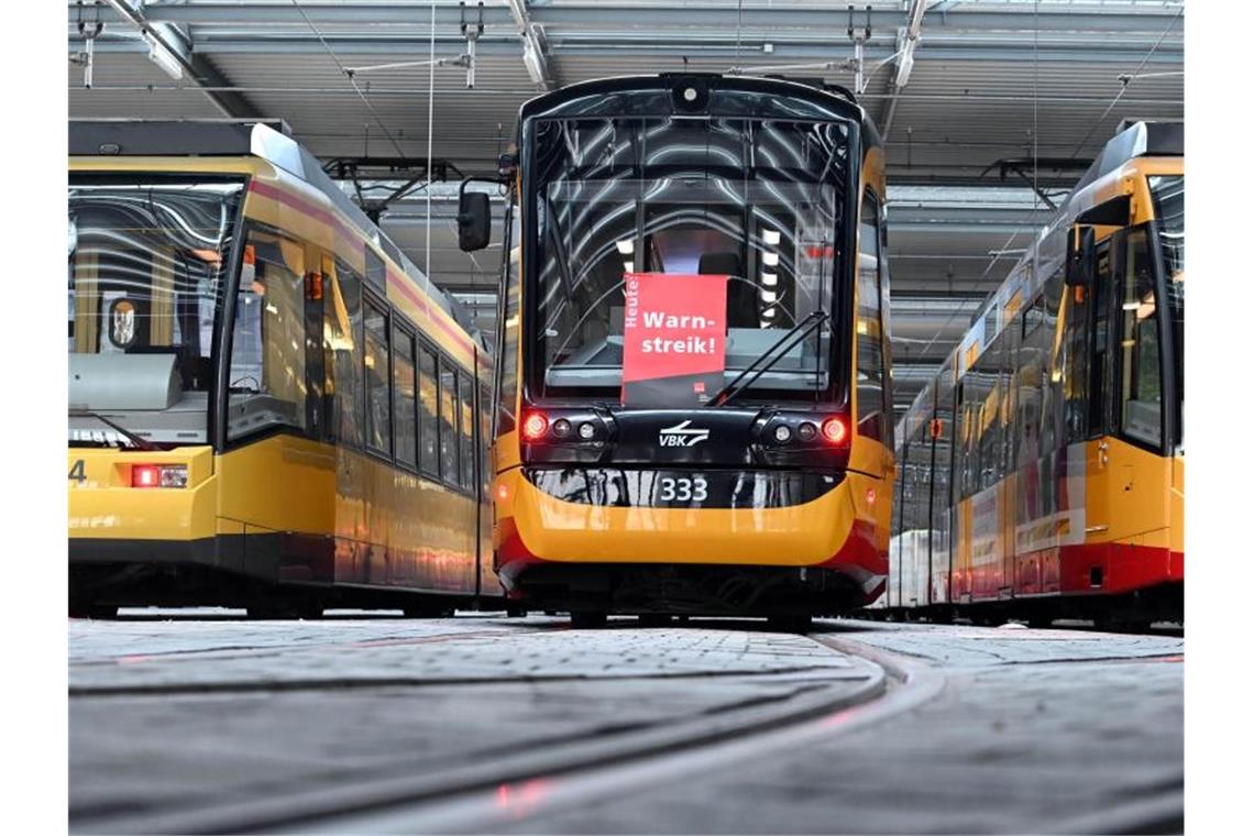 An einer Straßenbahn der Verkehrsbetriebe Karlsruhe hängt ein Plakat mit der Aufschrift Warnstreik. D. Foto: Uli Deck/dpa