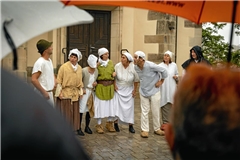 An mehreren Stellen in Backnang geben die Mitglieder des Theaters Rietenau mit urschwäbischem Humor Einblicke in die Backnanger Geschichte – natürlich auch bei Regen, so wie hier im Jahr 2022. Archivfoto: Alexander Becher