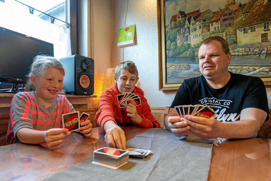 Ana, Lukas und Stefan Pfisterer verbringen die gemeinsame Zeit gerne mit Spielen wie Uno. Samuel, das dritte und jüngste Kind im Bunde, ist an diesem Tag auf dem Flohmarkt an der Plaisirschule unterwegs. Foto: Alexander Becher