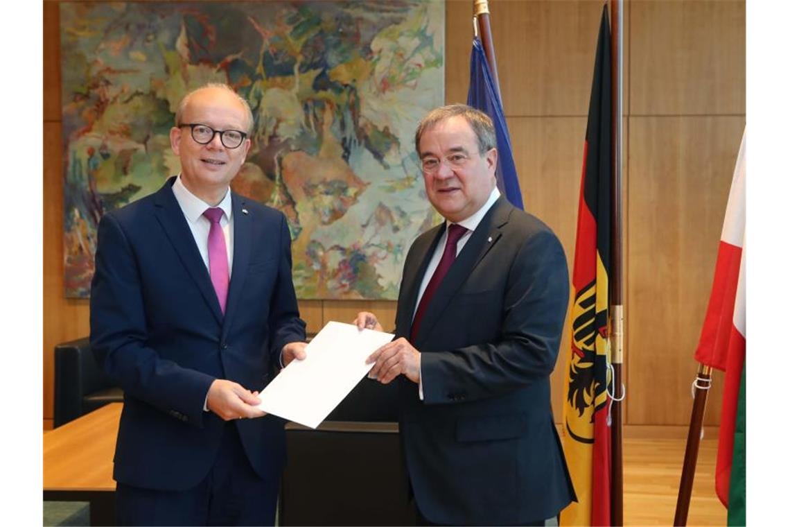Laschet legt Amt als Ministerpräsident nieder André Kuper (l) überreicht Armin Laschet die Urkunde über die Beendigung des Amtes als Ministerpräsident. Foto: Bernd Schälte/Landtag NRW/dpa