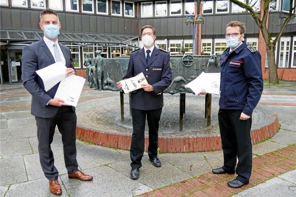 Andreas Schmidt aus dem Innenministerium (Mitte) übergibt Dezernent Stefan Hein (links) und Kreisbrandmeister René Wauro die BOS-Sicherheitskarten. Foto: Landratsamt