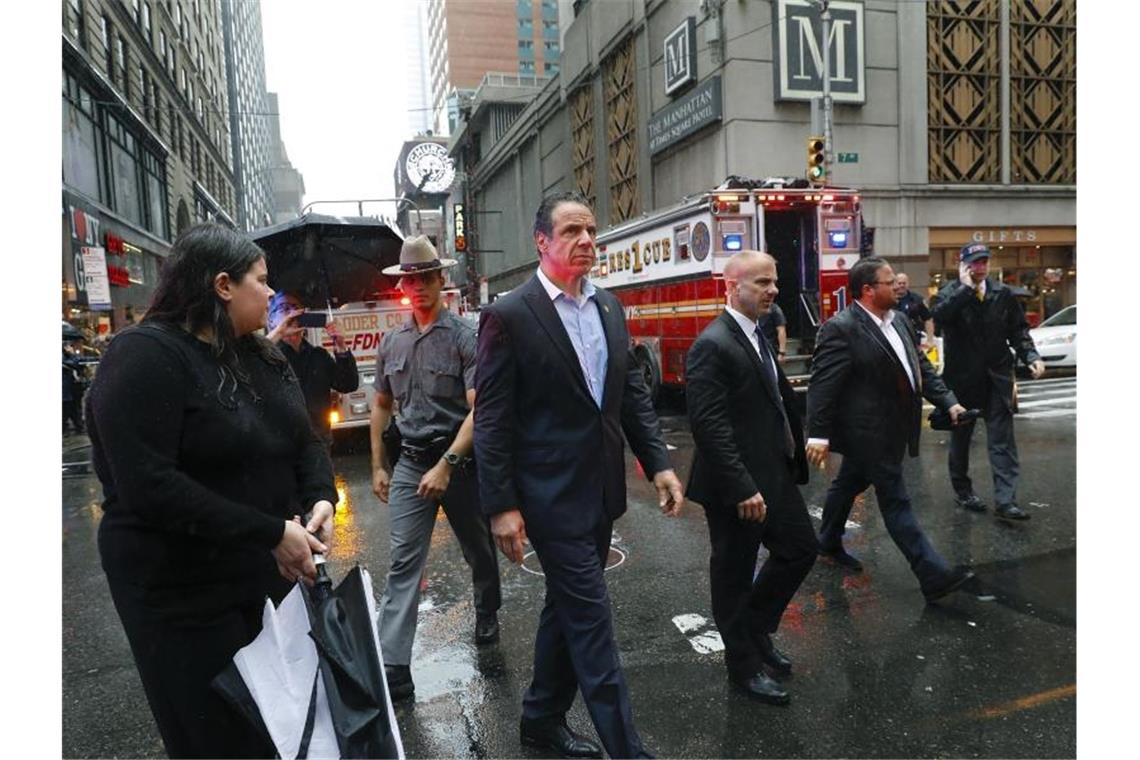 Andrew Cuomo (M), Gouverneur des Bundesstaates New York, ist nach dem Unglück nach Manhattan gekommen. Foto: Mark Lennihan/AP
