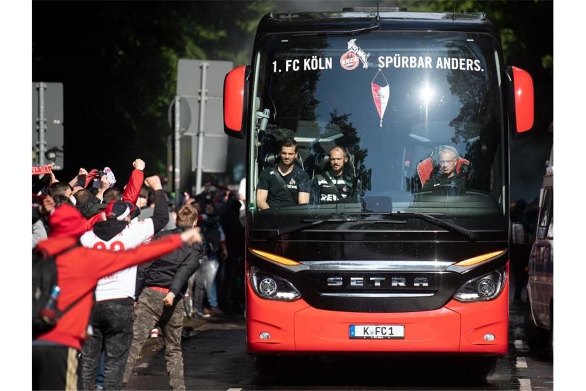 Anfeuerung vor dem Spiel: Der Kölner Bus wird von zahlreichen FC-Fans vor dem Stadion begrüßt. Foto: Federico Gambarini/dpa