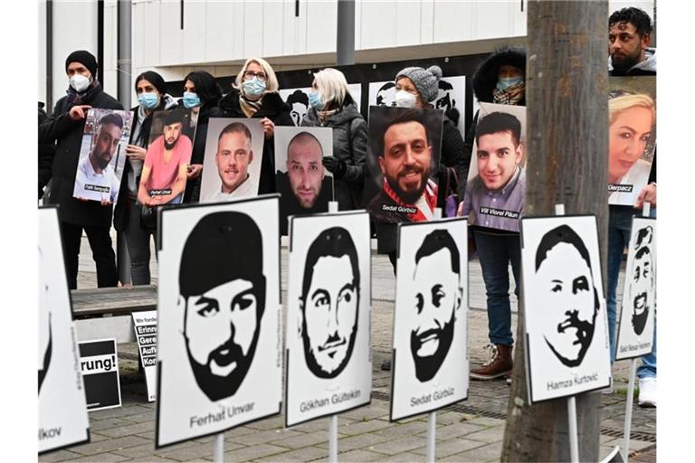 Angehörige der Opfer des rassistischen Anschlags von Hanau 2020 halten bei einer Mahnwache vor dem hessischen Landtag Fotos der Opfer. Foto: Arne Dedert/dpa