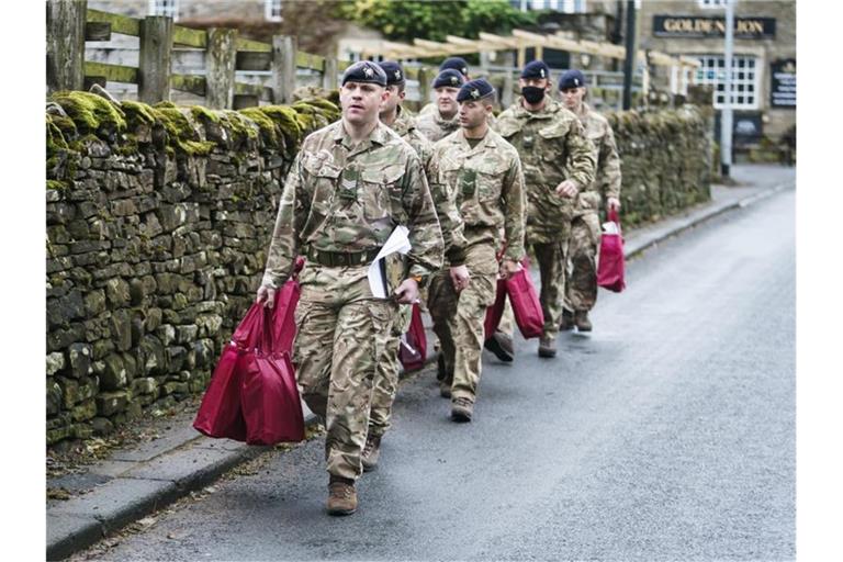 Angehörige der Streitkräfte tragen Versorgungspakete, um sie an Betroffene im britischen St. John's Chapel zu verteilen. Foto: Danny Lawson/PA Wire/dpa
