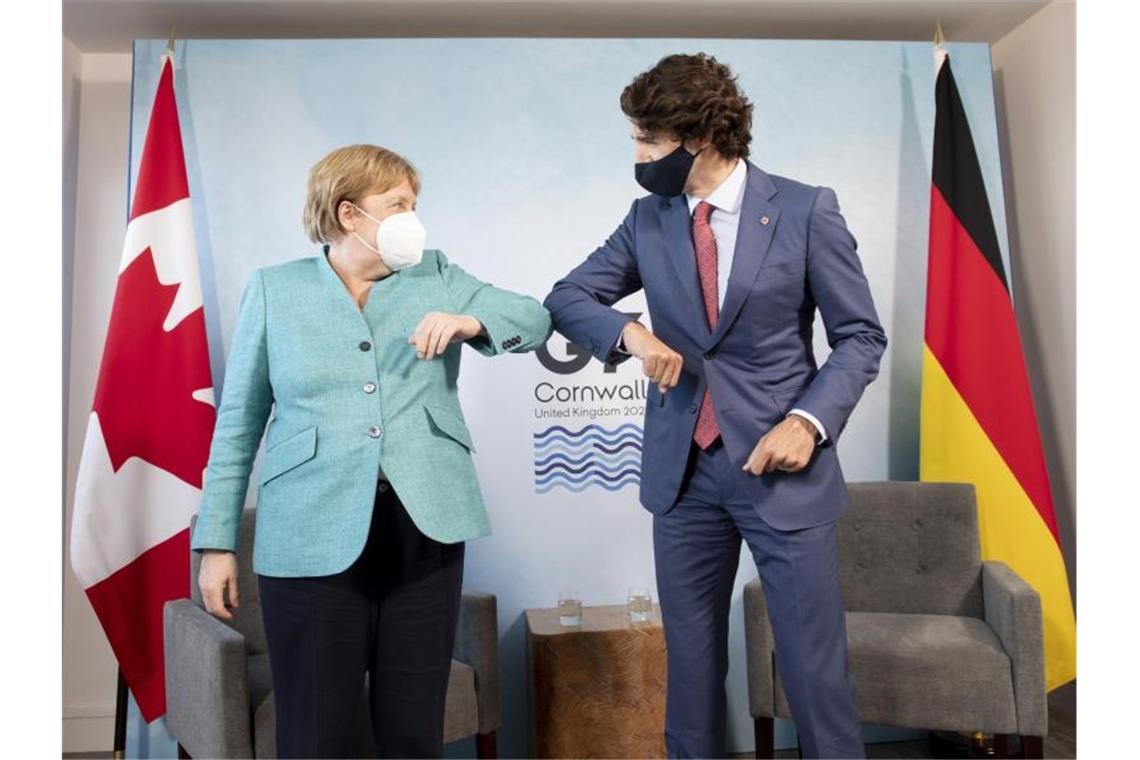 G7 einigt sich auf Impfversprechen und harten China-Kurs Angela Merkel, Bundeskanzlerin von Deutschland, und Justin Trudeau, Premierminister von Kanada, begrüßen sich während des G7-Gipfels. Am letzten Tag beschäftigen sich die teilnehmenden Staats- und Regierungschefs hauptsächlich mit dem Thema Klimawandel. Foto: Adrian Wyld/The Canadian Press/AP/dpa