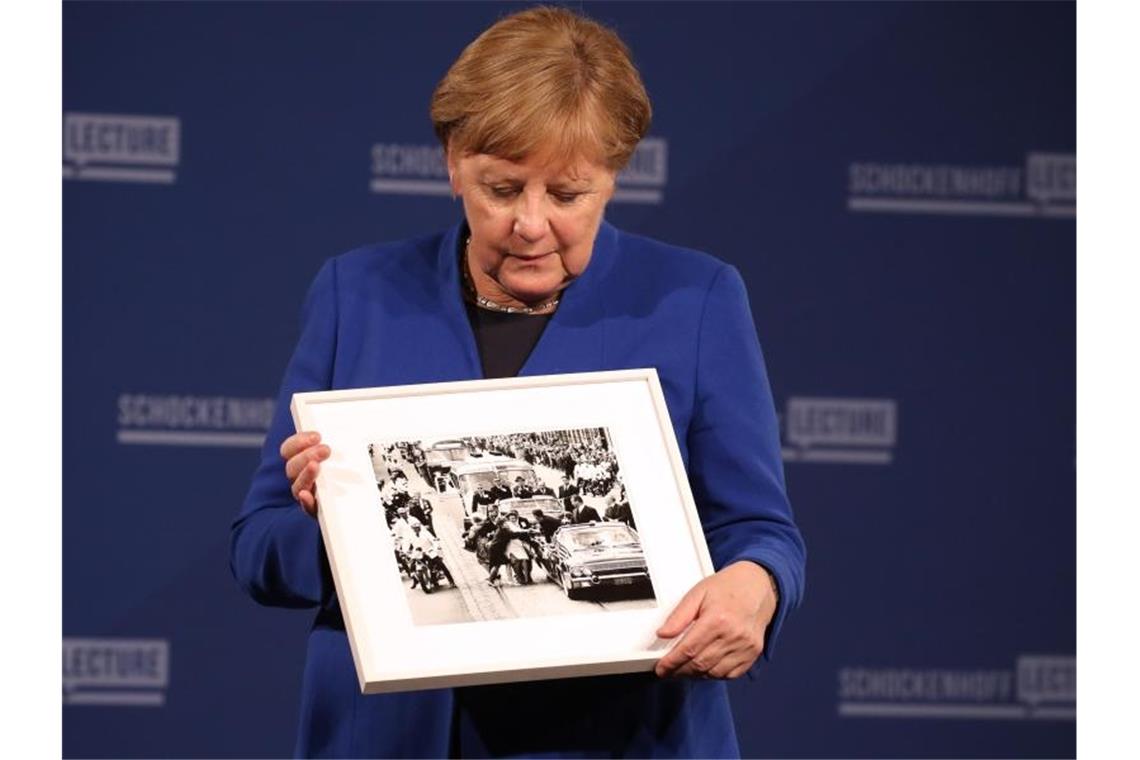 Merkel: Atomdeal mit Iran „kann Schlimmeres verhindern“ Angela Merkel (CDU) hält bei der Premiere der Dr. Andreas Schockenhoff-Lecture ein Foto, das ihr geschenkt wurde. Foto: Karl-Josef Hildenbrand