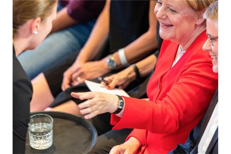 Angela Merkel lässt sich vor Beginn der Konferenz "Morals & Machines" in der Frauenkirche ein Glas Wasser servieren. Foto: Robert Michael