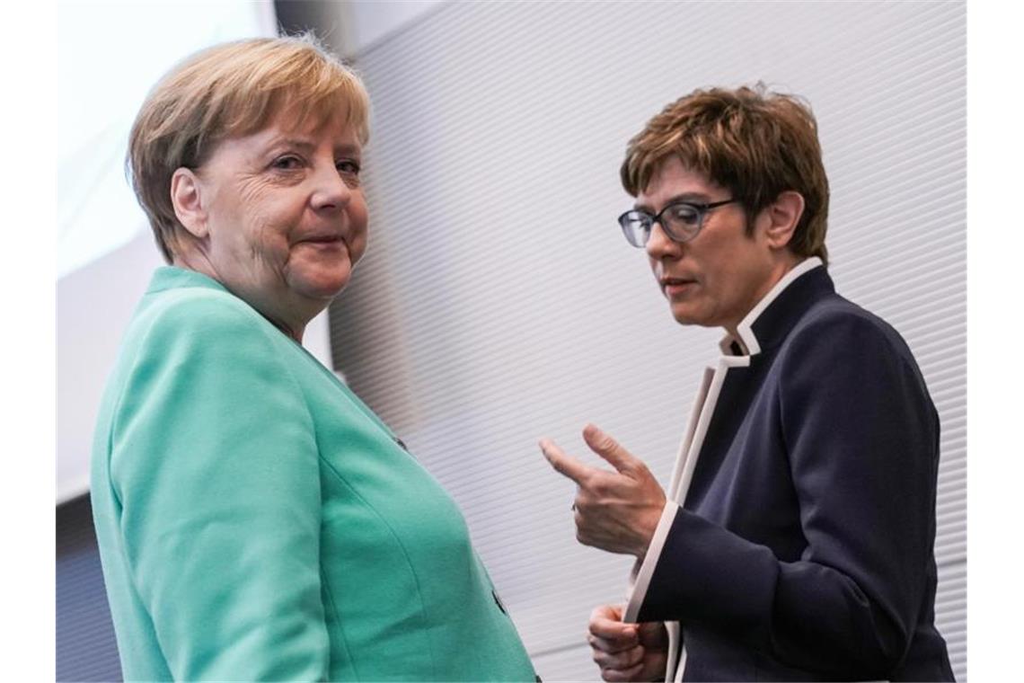 AKK will mehr Geld für die Truppe und wirbt für Nato-Ziele Angela Merkel und Annegret Kramp-Karrenbauer sprechen vor einer Fraktionssitzung. Foto: Michael Kappeler