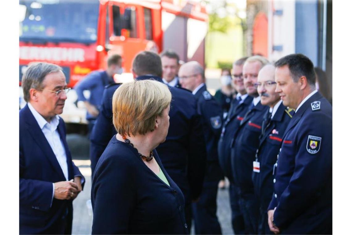 Merkel und Laschet in den Flutgebieten Angela Merkel und Armin Laschet besuchen das Feuerwehrhaus Schalksmühle. Foto: Thilo Schmuelgen/Reuters Pool/dpa