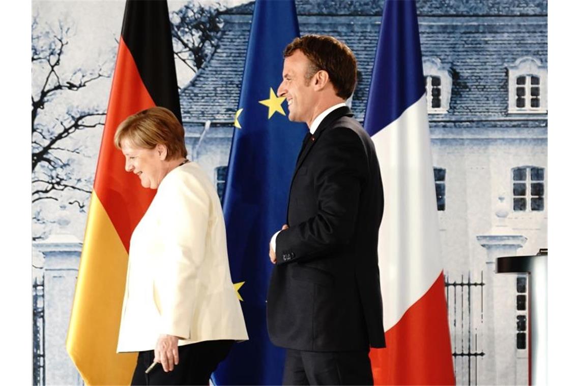 Angela Merkel und Emmanuel Macron verlassen die Pressekonferenz nach ihrem Treffen im Schloss Meseberg. Foto: Kay Nietfeld/dpa-Pool/dpa