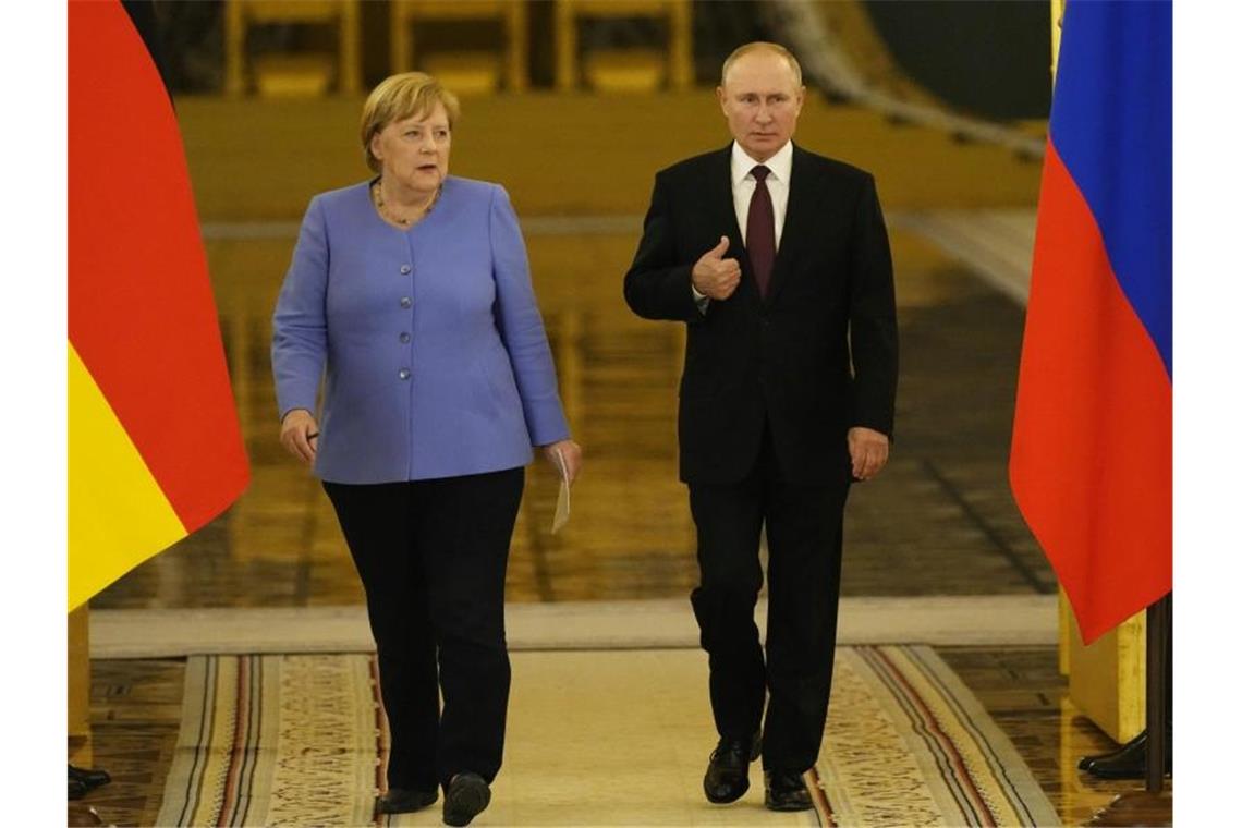 Angela Merkel und Wladimir Putin betreten den Saal für eine gemeinsame Pressekonferenz nach ihren Gesprächen im Kreml. Foto: Alexander Zemlianichenko/AP/dpa
