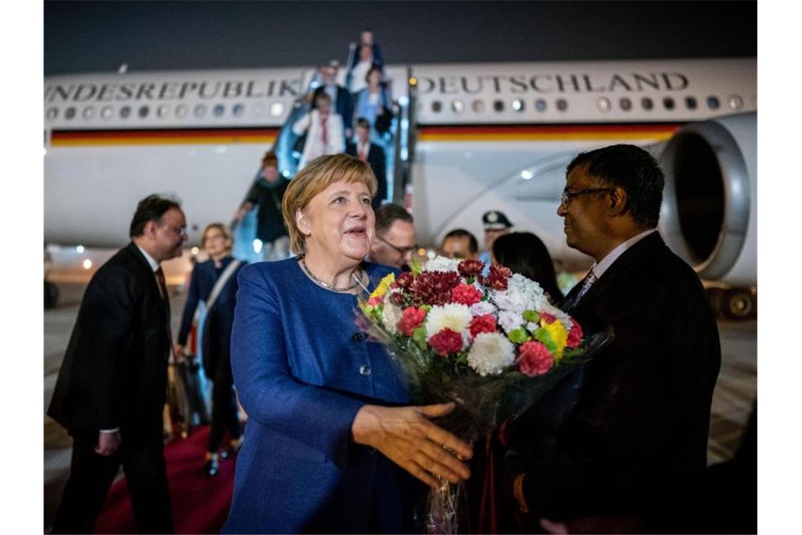 Angela Merkel wird in Neu Delhi am Flughafen begrüßt. Foto: Michael Kappeler/dpa
